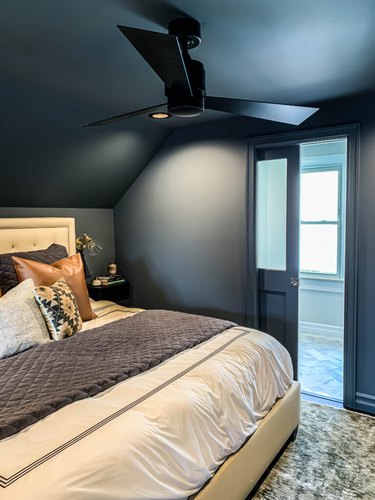 Attic bedroom idea with blue-gray walls and king bed