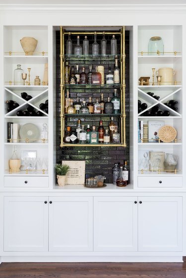 white industrial bar idea with black brick center and brass pipe shelves