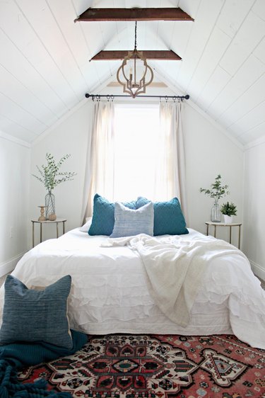 Attic bedroom idea with white bed linens and vintage patterned rug
