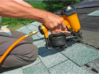 Roofer using a nail gun.