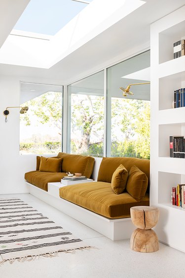 living room with a built-in ochre velvet sofa