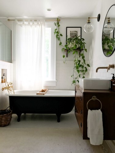 vintage bathroom lighting idea with midcentury wall sconce and clawfoot bathtub