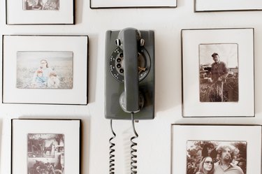Personal photographs surround a vintage rotary phone.