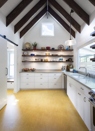 yellow linoleum kitchen flooring with open shelving and exposed ceiling beams