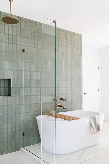 Modern bathroom with freestanding bathtubs next to green wall tile