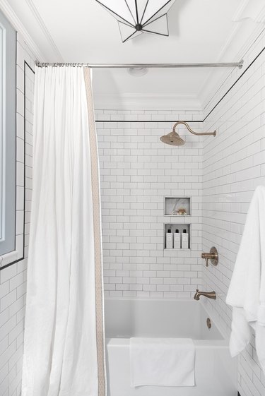 Modern bathroom with alcove bathtubs surrounded by subway tile