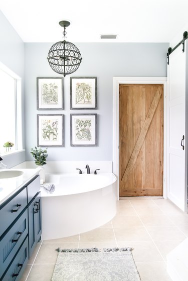 Modern blue bathroom with corner bathtubs with pendant hanging above