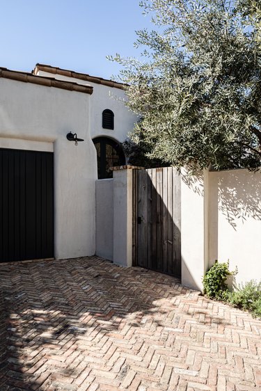 brick driveway in a herringbone pattern by a Spanish-style home