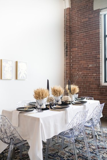 Dried wheat fall centerpieces with black candles in modern dining room