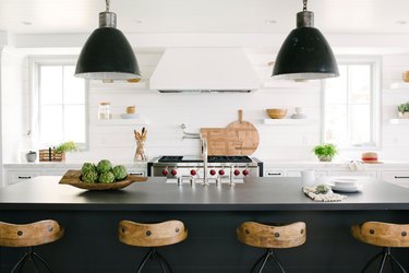 Modern coastal kitchen ideas with black island and wood bar stools