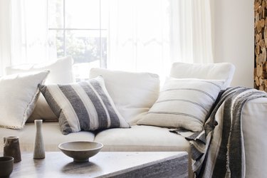 white living room with striped accent pillows and throw blanket