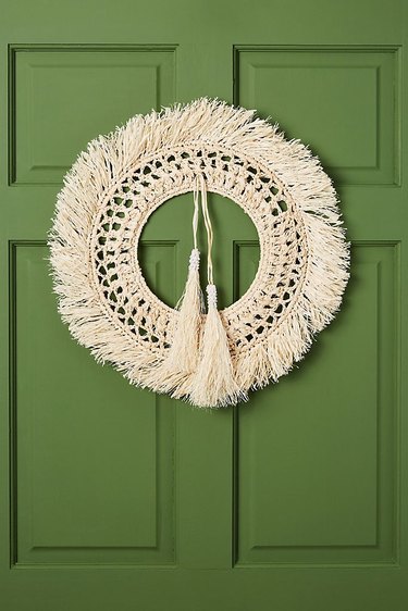 Christmas Door Decorations with Straw wreath on green door.