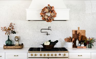 fall kitchen decor in white kitchen with wreath hanging on hood