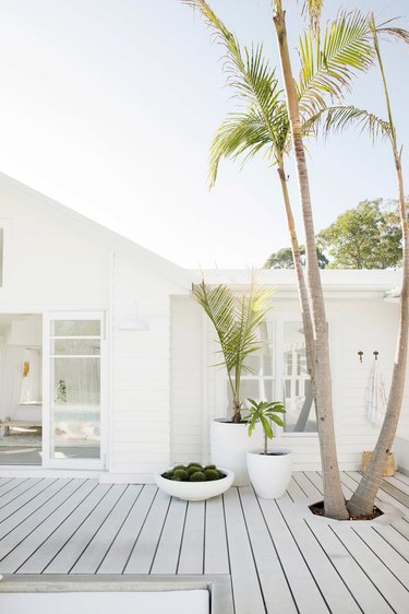 White exterior beach house colors with deck and palm trees