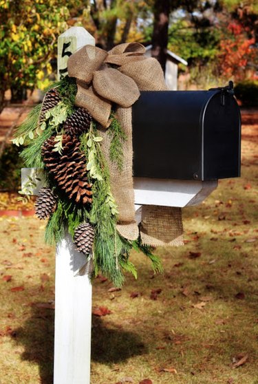 exterior Christmas decorations with Black mailbox with pine cone and greenery holiday decor.