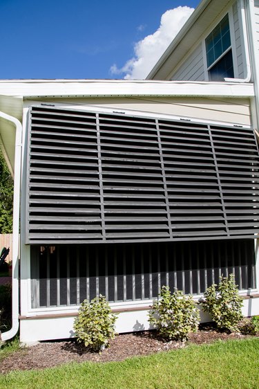 Black Bahama  exterior shutter style on traditional home alongside landscaping