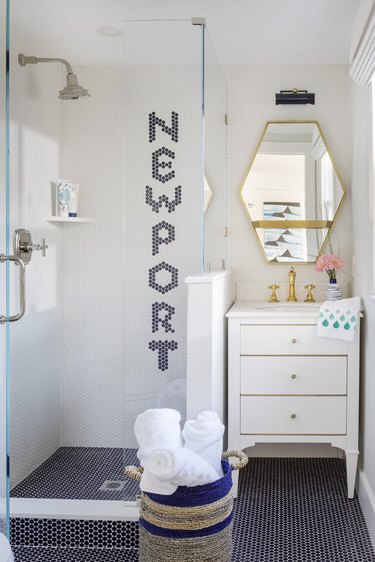 Navy blue penny tile coastal flooring idea in bathroom with white vanity