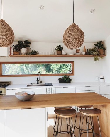 kitchen island lighting idea with woven bohemian pendant lights and wood waterfall countertop