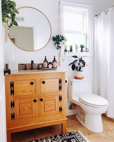 Bathroom with potted plants in windowsill above toilet