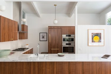 midcentury kitchen lighting idea with circular pendant and wall sconces