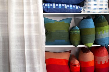 built-in bookcase filled with colorful patterned accent pillows