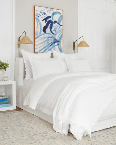 White and cream coastal bedding idea with modern blue artwork and white bedding