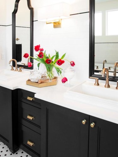 black vanity cabinet with brass hardware and his and hers sinks