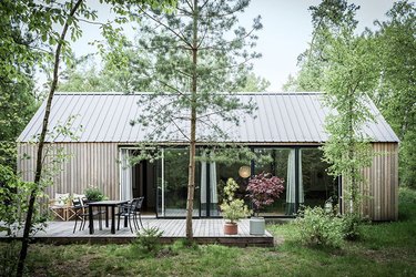 Scandi-inspired cabin with natural wood exterior and glass wall