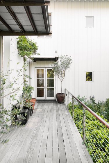 white home exterior with gray deck and modern railing