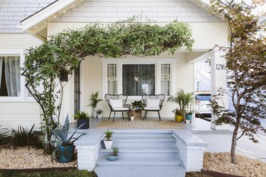 white home exterior with light blue porch steps and greenery