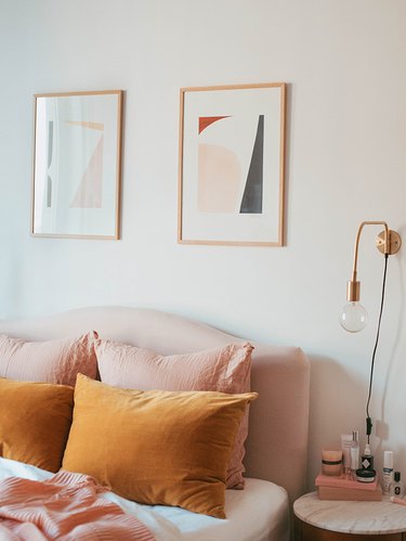 modern pink and orange bedroom with brass wall sconce