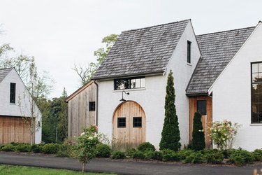 white home exterior with wooden doors and gray roof