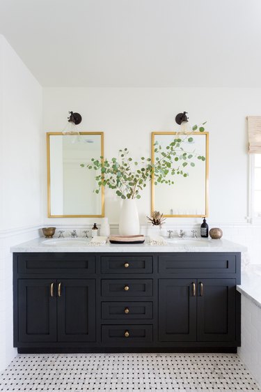 black vanity cabinet with black and white mosaic flooring