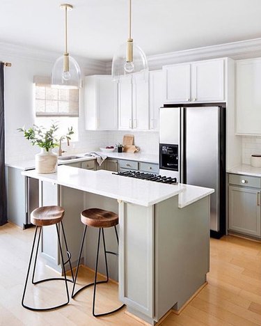 gray and white kitchen with two tone cabinets and stainless steel appliances