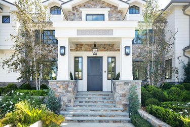 Stone Exterior Homes with white siding home by Kelly Nutt Design