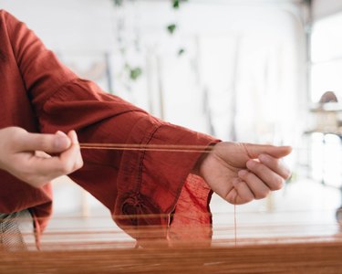 hands putting material together for a wall hanging