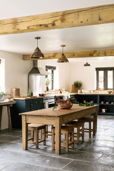 limestone kitchen flooring with dark cabinets and exposed ceiling beams