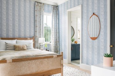 periwinkle wallpaper and leather bed in coastal bedroom