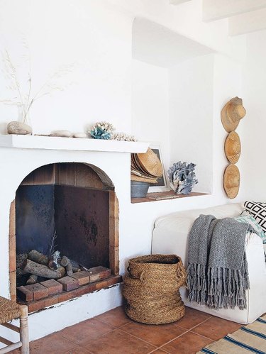 white living room with coastal fireplace and basket next to it