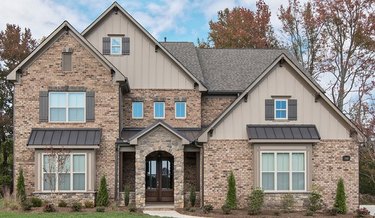 Brown brick house with taupe siding