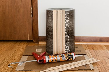 Glue the cut dowels to the sides of the trash can.