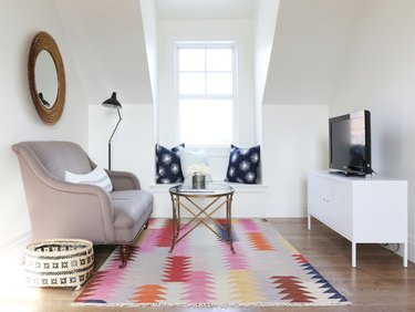 white finished attic idea for tv room with sofa and colorful rug