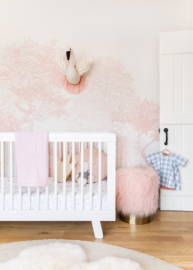 pink-and-white wallpaper in a nursery with white crib