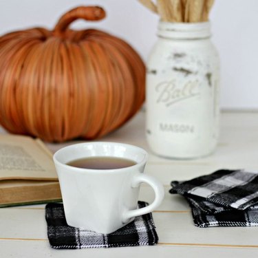 DIY fall decor idea with cup of coffee on a tabletop with flannel coasters