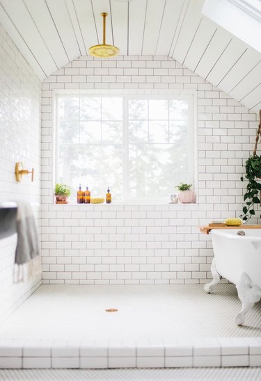 white finished attic idea for bathroom with subway tiles and clawfoot tub