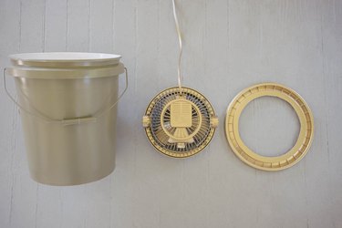 Plastic bucket painted olive green and fan painted gold