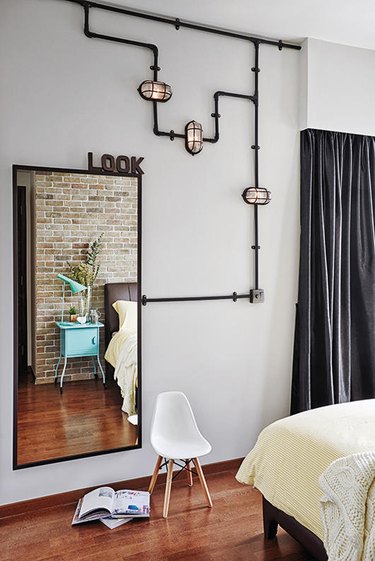 industrial bedroom with decorative pipe artwork running along wall