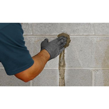 A man applying hydraulic cement to a wall.