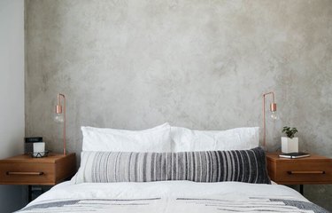 industrial bedroom with concrete walls and copper table lamps