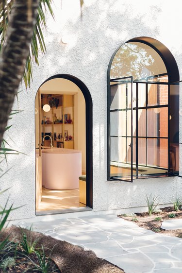 white exterior with arched window and door